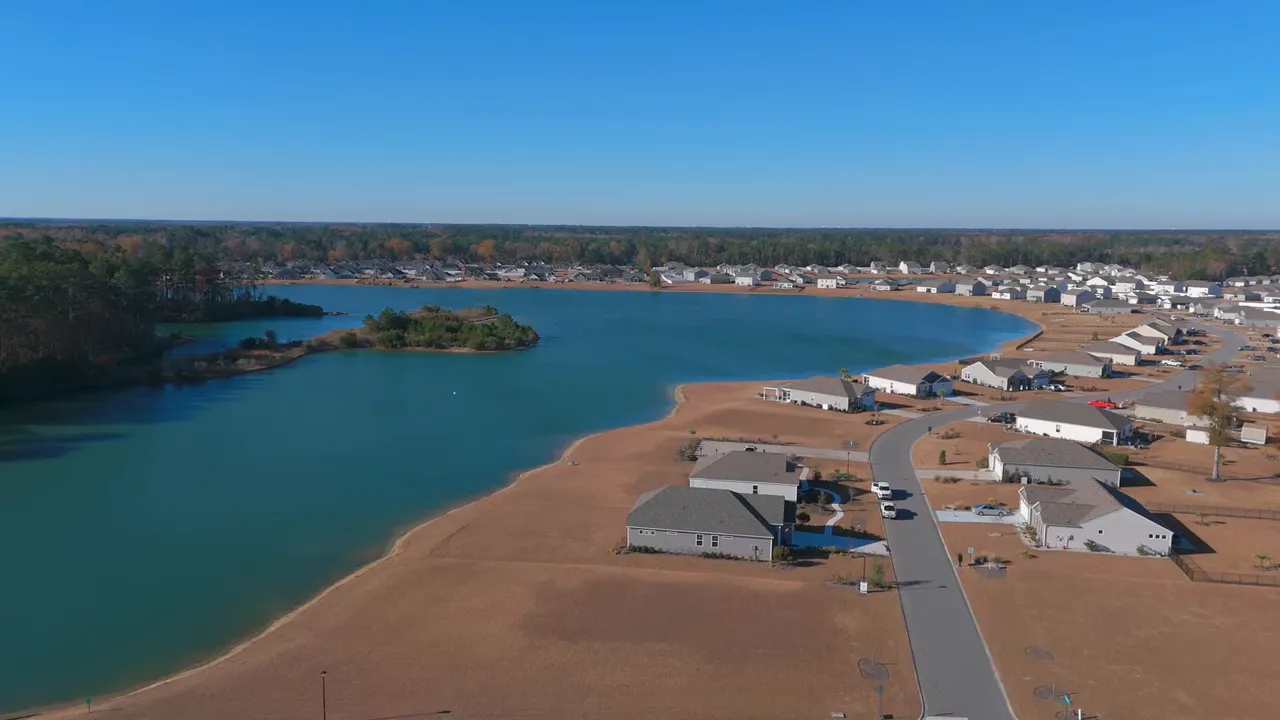 Drone aerial of Lockhaven showing the lake, sandy shoreline and rows of new homes with overlay text 'Lockhaven CONWAY S.C.'