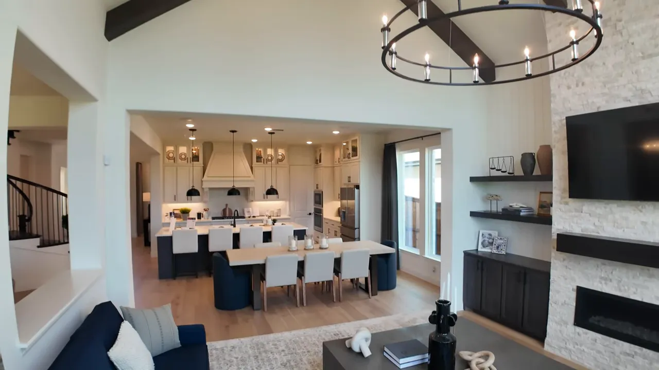 Vaulted ceiling with dark beams and chandelier above open living area