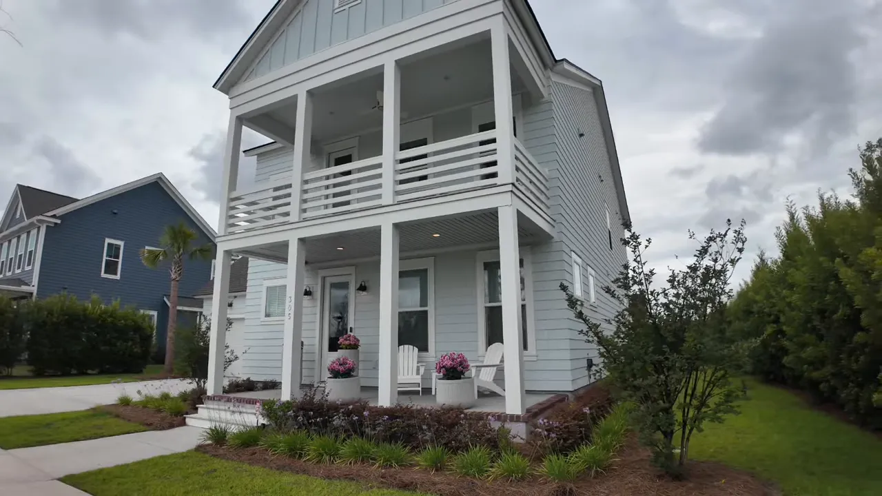 Light blue home with two stacked front porches and white railings