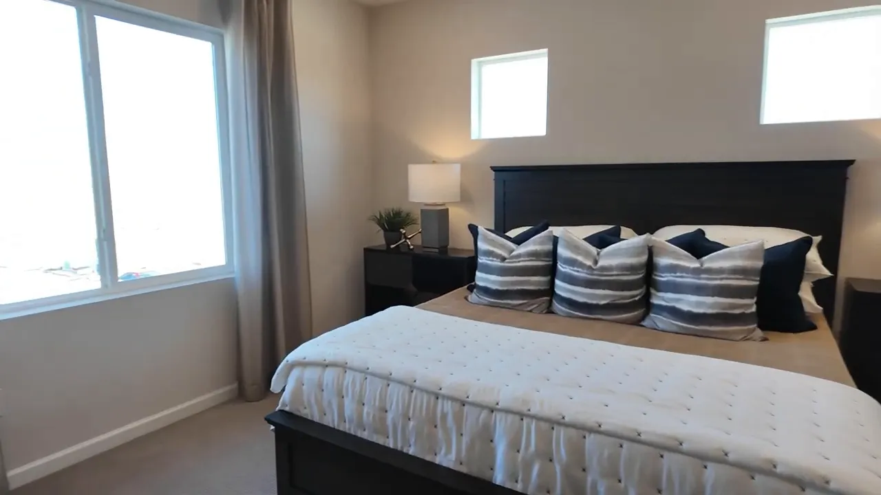 Primary bedroom sitting area with upholstered chair and warm lighting in a Tri Pointe home at Aurora Highlands