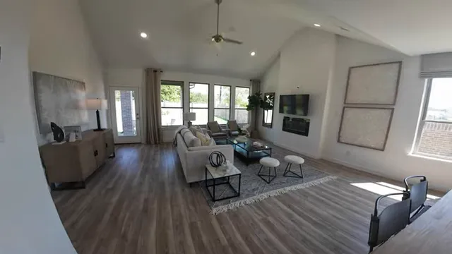 Upstairs game room with sectional sofa, coffee table, and windows