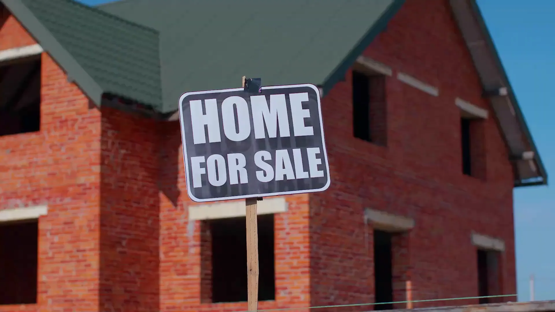 Home for sale sign with 490000 dollar price label in front of a brick house