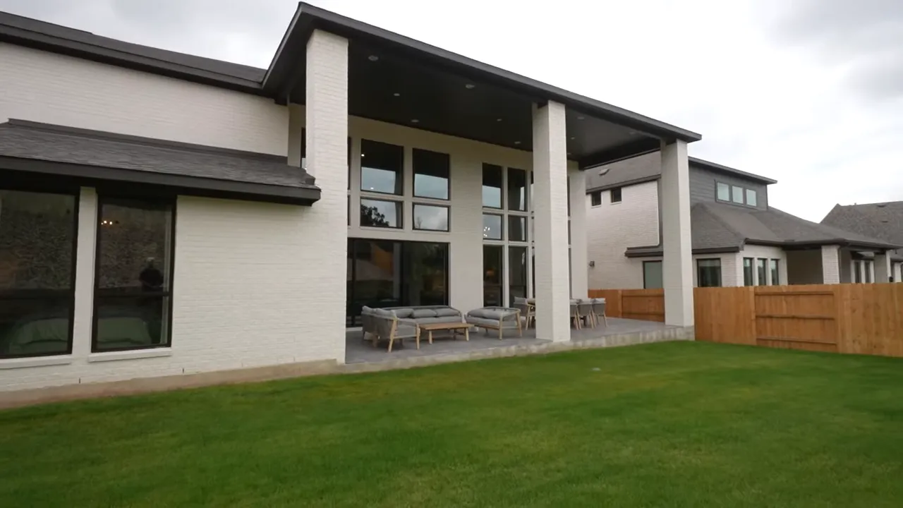 Realtor pointing toward large sliding doors leading to the patio area
