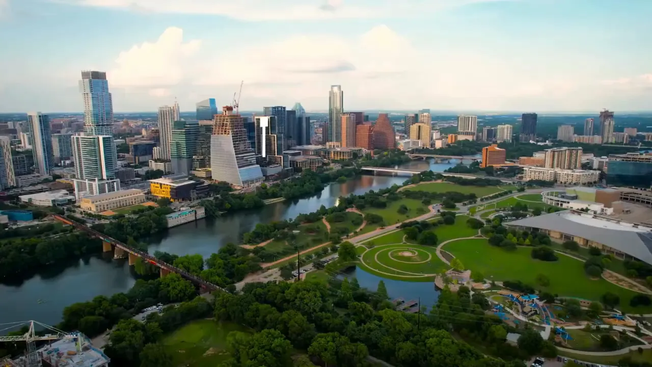 Host speaking on camera in front of a wooden shelving unit while describing HOA costs