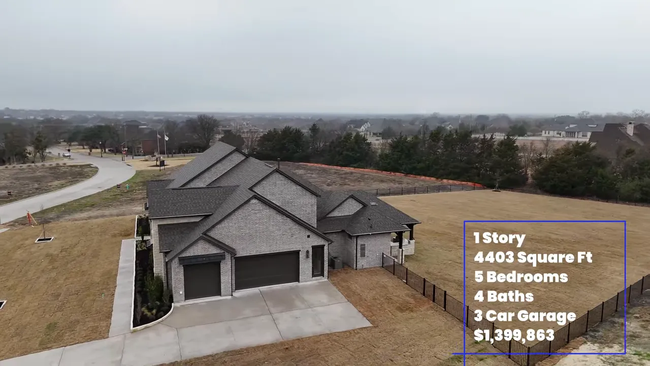 Wide view from the foyer into an open living area with large windows, high ceilings and a round chandelier.