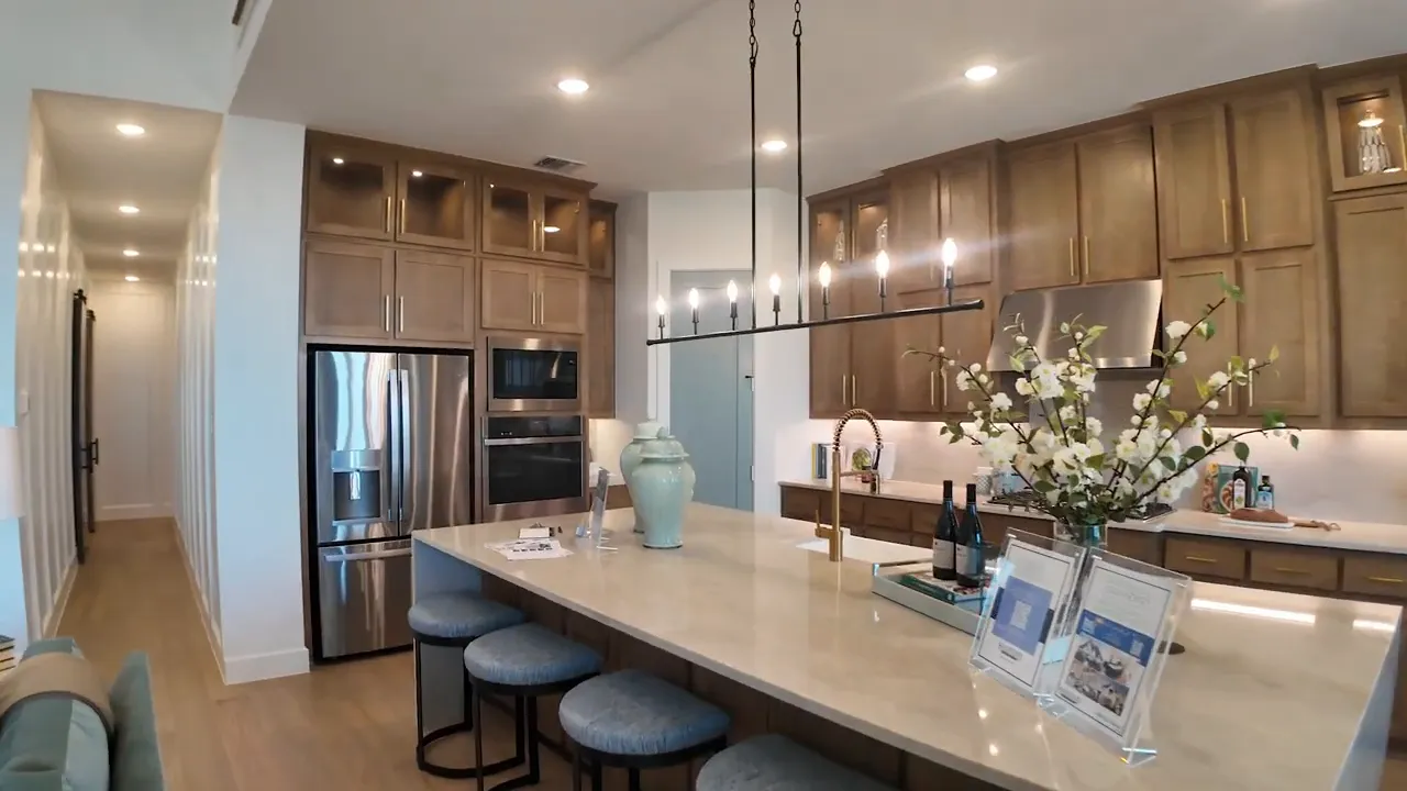 Long wall of wood kitchen cabinets with glass uppers and under cabinet lighting