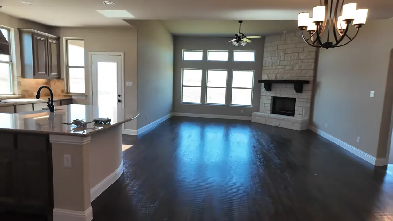 Kitchen with rounded granite island and brown cabinets