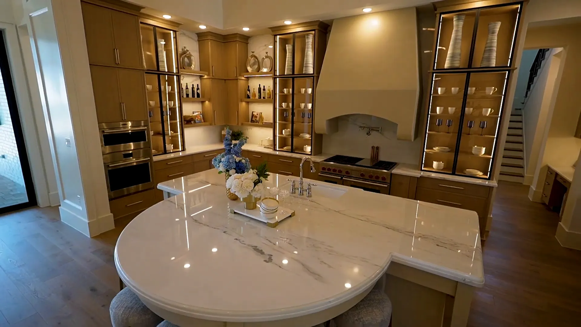 Main kitchen with semi-circular island and marble backsplash