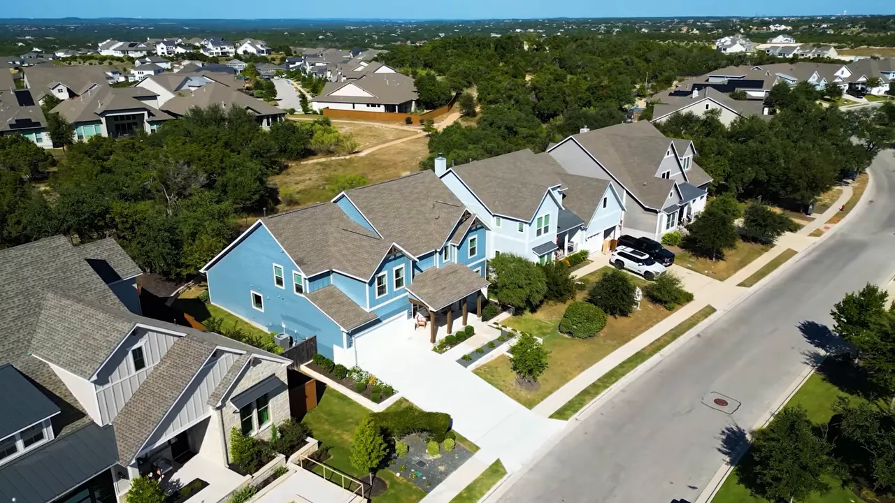 Aerial view of Dripping Springs area with winding roads, green trees, and residential neighborhoods