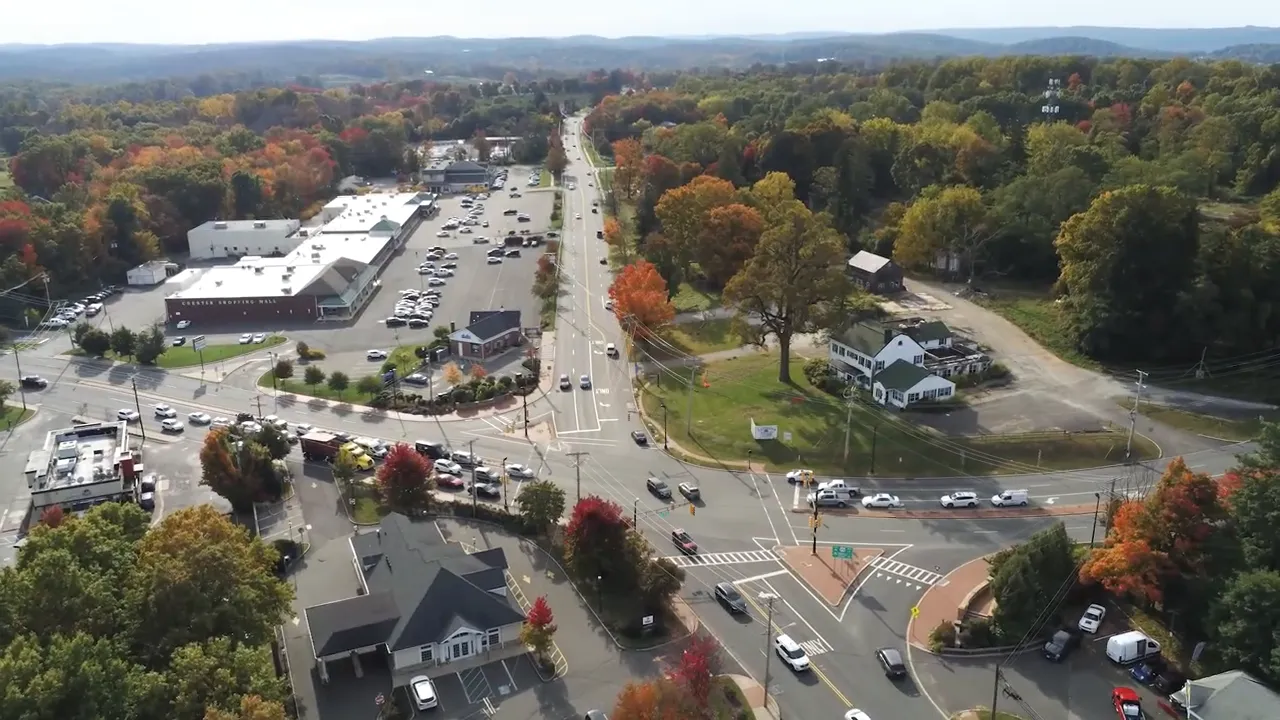 Driver-view of Main Street in Chester NJ showing shops and a marked arrow to Taylor's Ice Cream on the right side of the street.