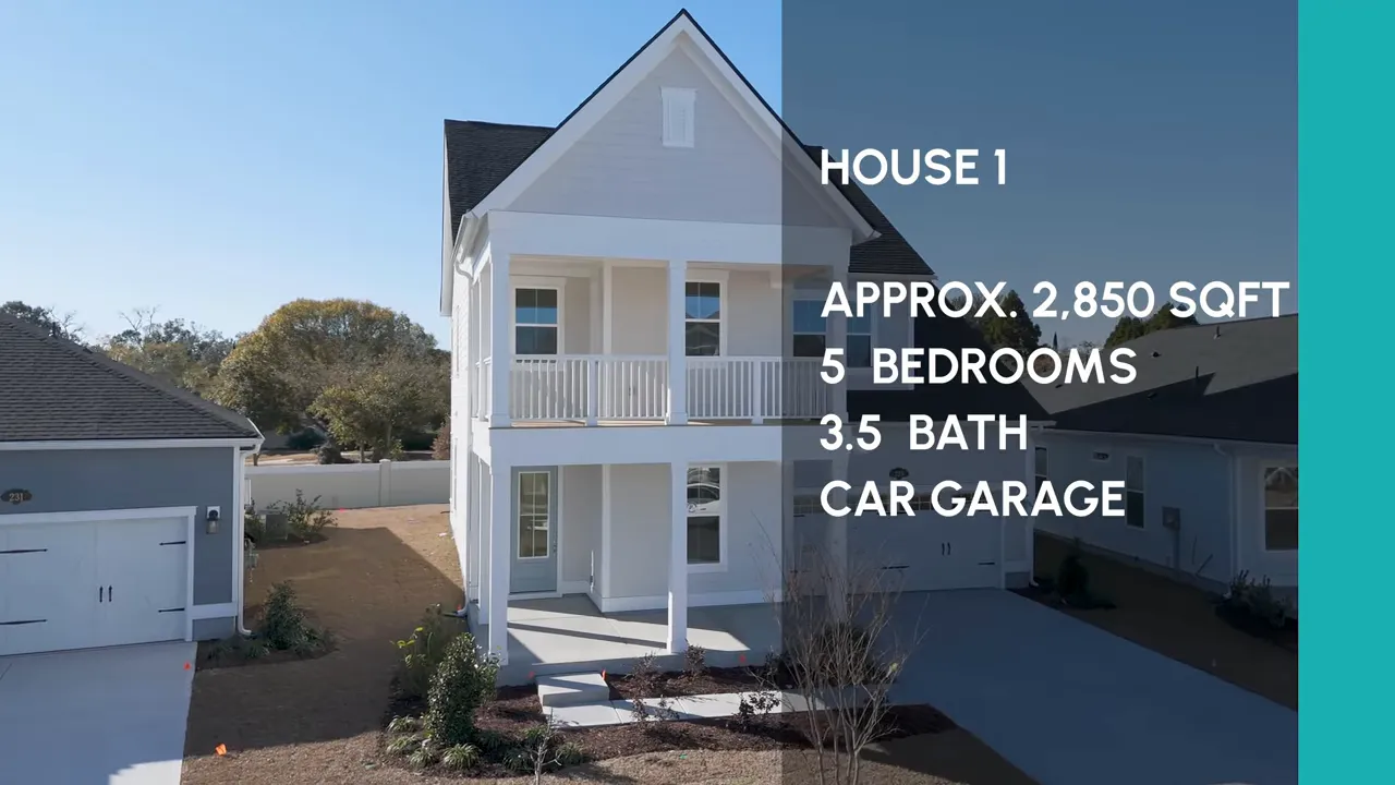 Open foyer with wooden staircase leading to a bright living area and kitchen with large windows
