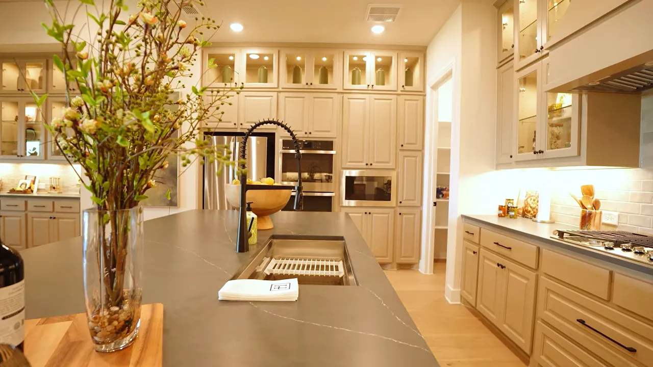Kitchen with gas cooktop vent hood double ovens and large island