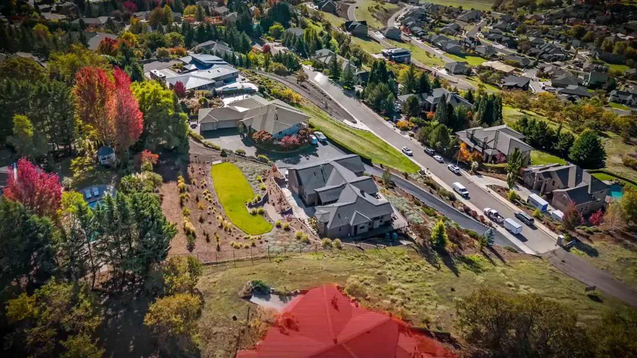 wide-angle view of paved road and adjacent undeveloped parcel with visible lot markers