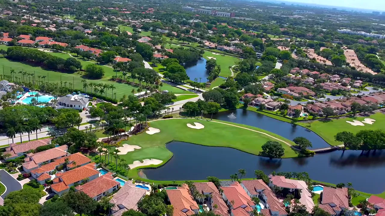 Sunlit clubhouse lounge with large windows, sectional sofa and glass coffee table