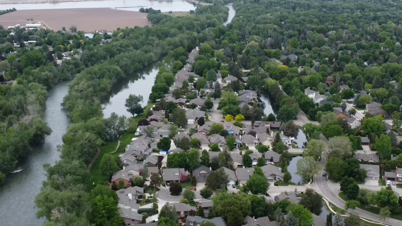 Presenter holding papers in a modern kitchen beside a double oven and gas cooktop