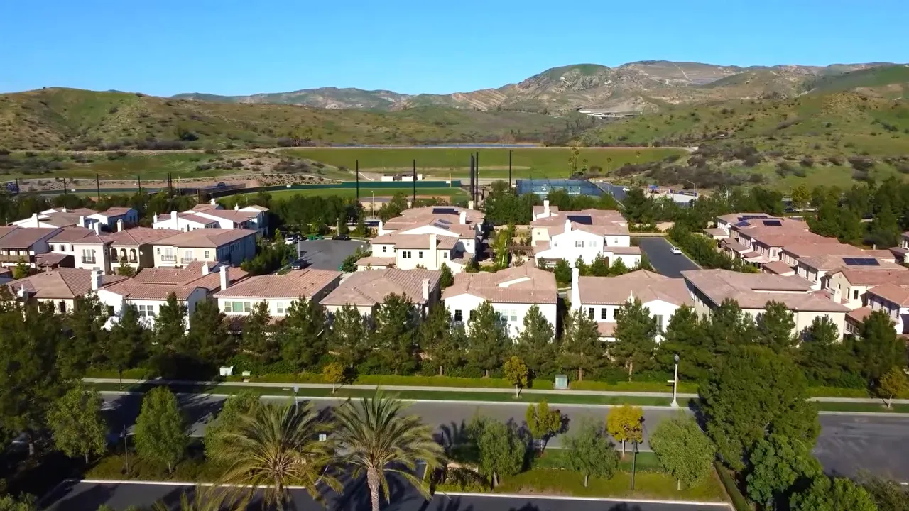 Hillside neighborhood with icons for wildfire risk zones complicated insurance and HOA litigation