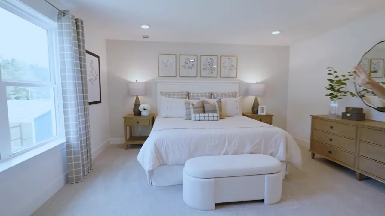Primary bedroom in a new construction home with large bed and window lighting