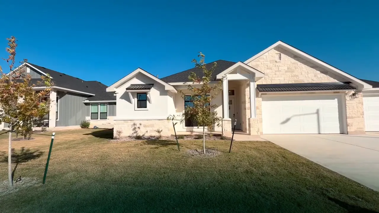 Open kitchen showing two-toned cabinets, large island and dining area with chandelier