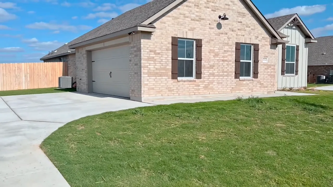 Open foyer and living room with wood-look plank flooring and back door windows, presenter at left edge