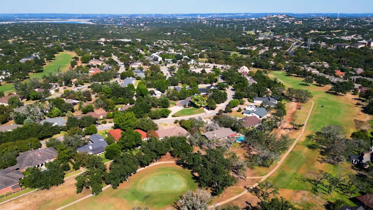 Real estate host speaking in an Austin suburbs neighborhood with rows of new homes