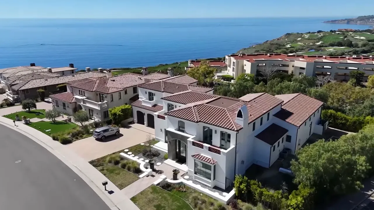 Aerial view of gated luxury homes surrounded by landscaped grounds