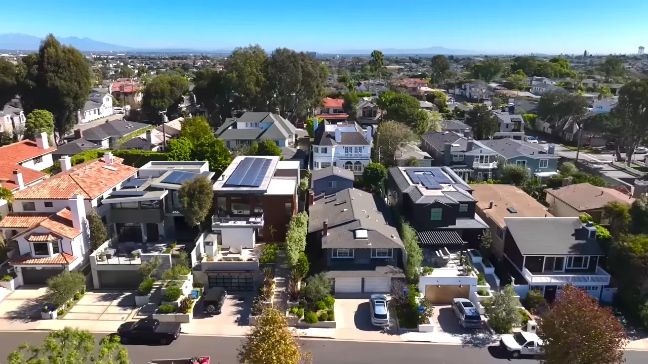 Los Angeles housing market trends dashboard with a line chart over an aerial neighborhood view