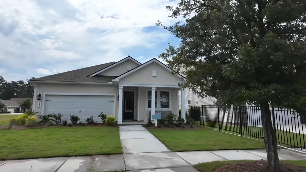Model home front porch with teal door, bench, and board-and-batten siding.