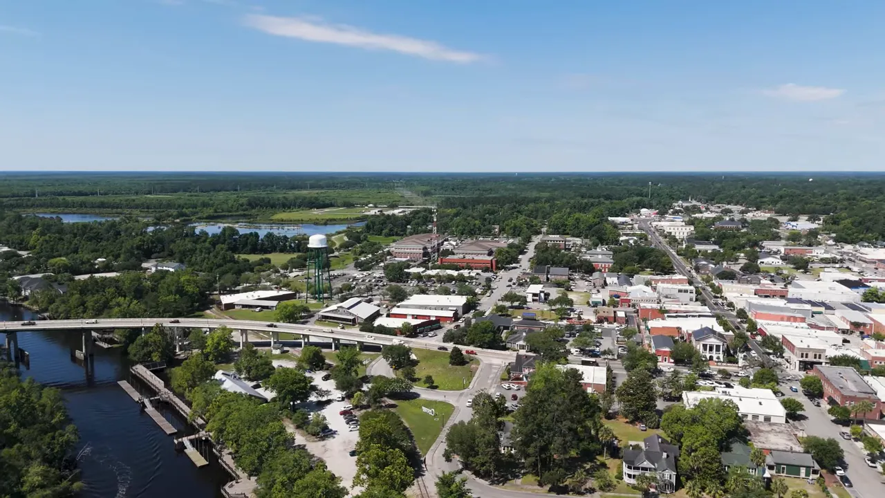 Shaded front porch with rocking chairs and white railing overlooking boats at a marina in Conway, SC