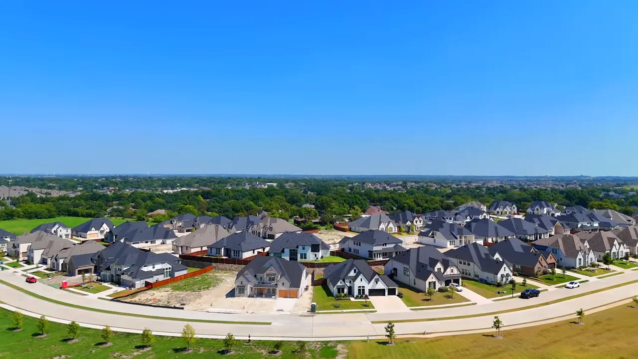 Aerial view of a neighborhood playground with shade canopies, benches and nearby raised garden beds at a community park.