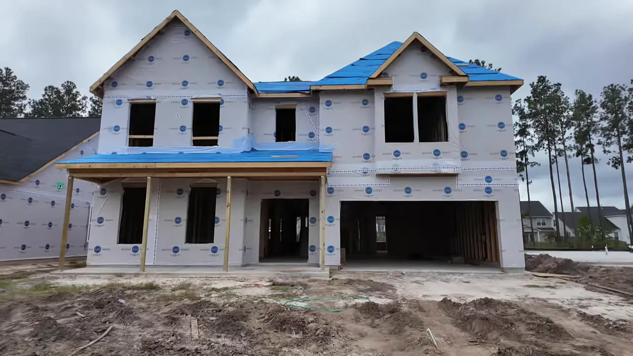 New construction house under roof at Lockton at Cane Bay with windows installed and exterior sheathing in place