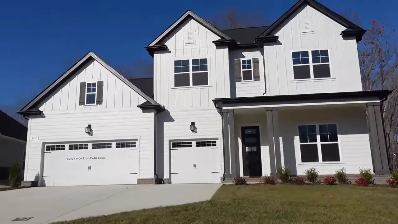 White two story home with covered front porch and three car garage