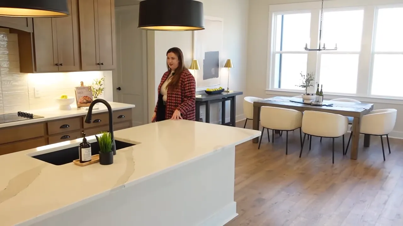 Kitchen with quartz island black farmhouse sink wood cabinets and white tile backsplash