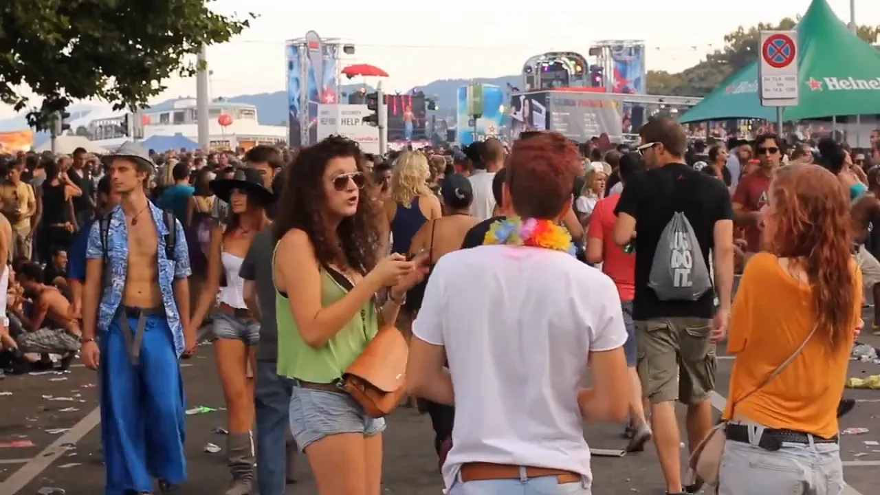 Blurred person in orange clothing seated behind a TV or monitor in foreground