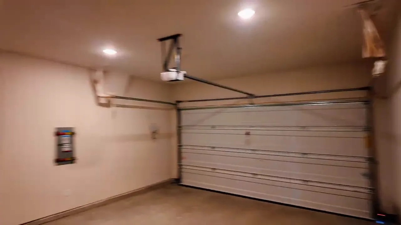 Two-car garage interior showing garage door hardware and utility wall in new construction home