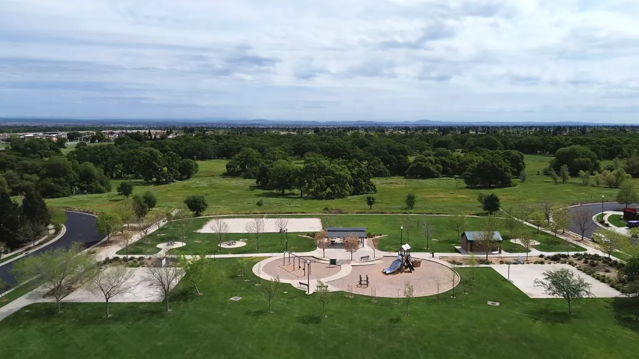 Aerial exterior view of two new-construction homes with 'Now Selling' signage and solar panels visible on roofs.