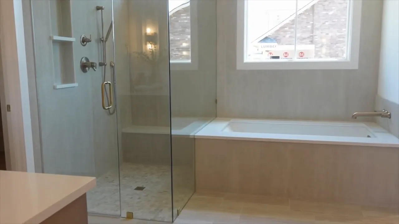 Primary bathroom with built in tub glass shower and large window