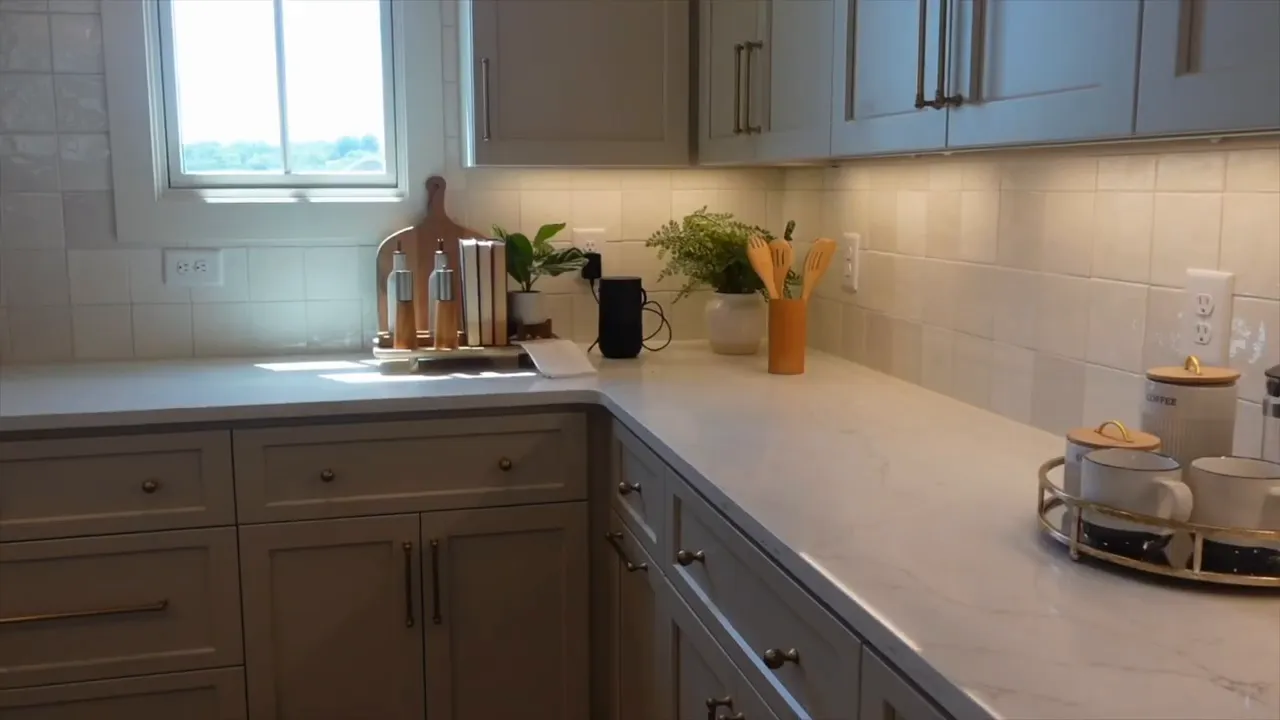Kitchen island with white countertop pendant lights sink and range hood