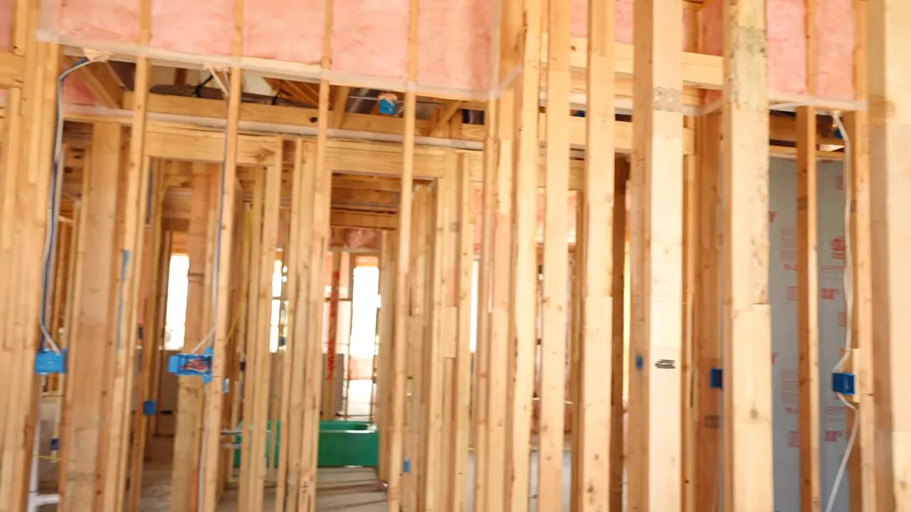 Close-up view of open wall insulation and framing studs during pre-drywall inspection