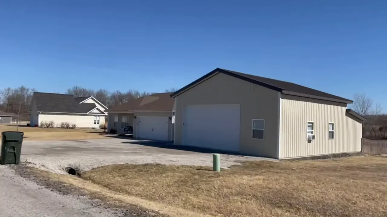 Newer single story homes with driveways garages mailboxes and trash bins in a neighborhood