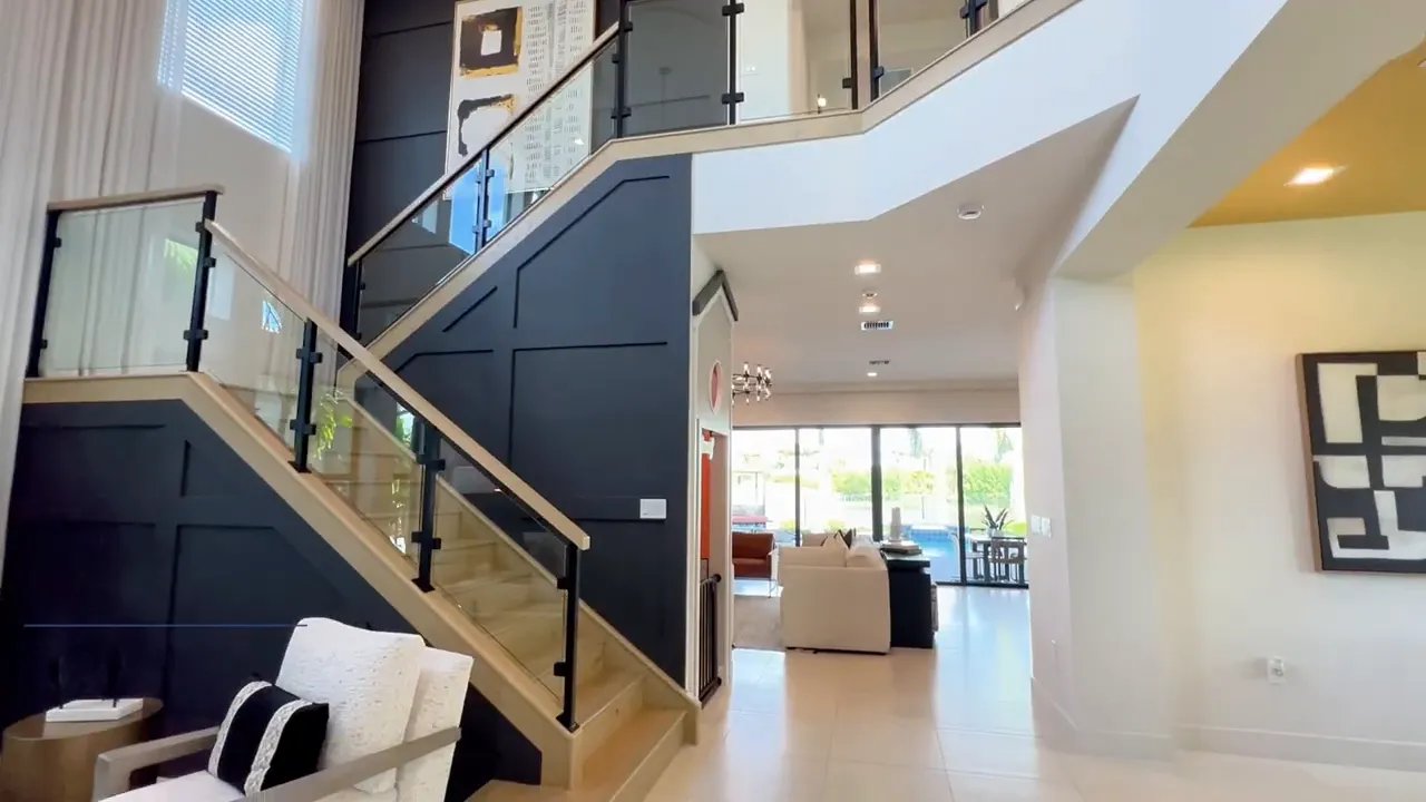 Polaris model home grand two-story entry with staircase and living space in Avenir Palm Beach Gardens