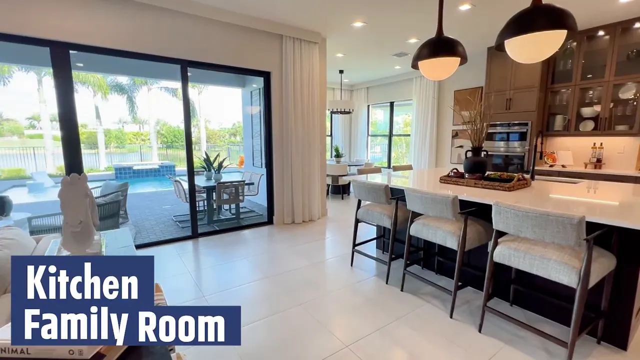 Polaris model kitchen and family room area with sliding doors to the pool patio at Avenir Palm Beach Gardens