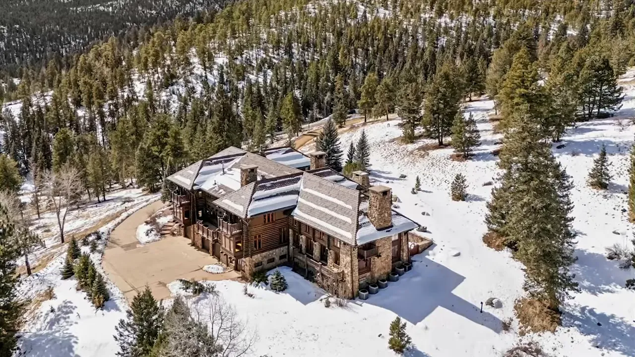 Aerial view of Captain Rock’s Ranch in Evergreen CO covered in snow and surrounded by mountains
