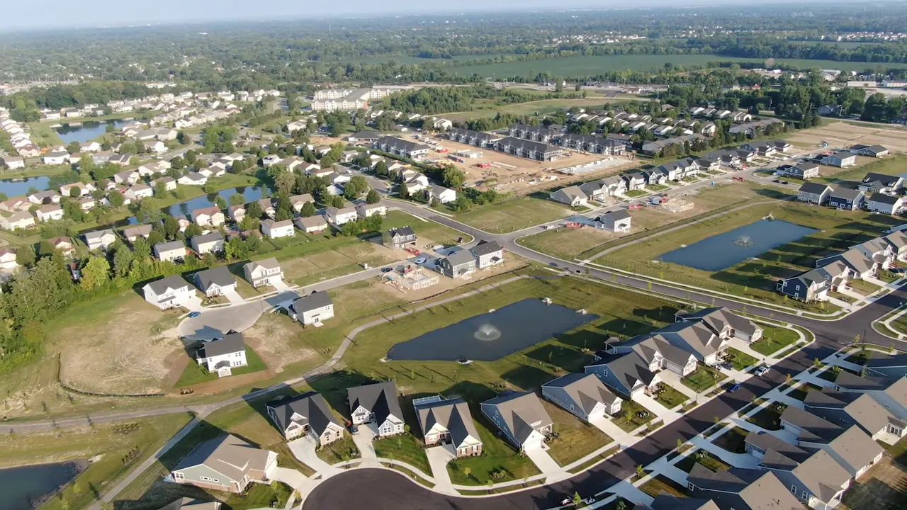 Host gesturing while summarizing action steps, studio backdrop with 'Living in Indianapolis' sign