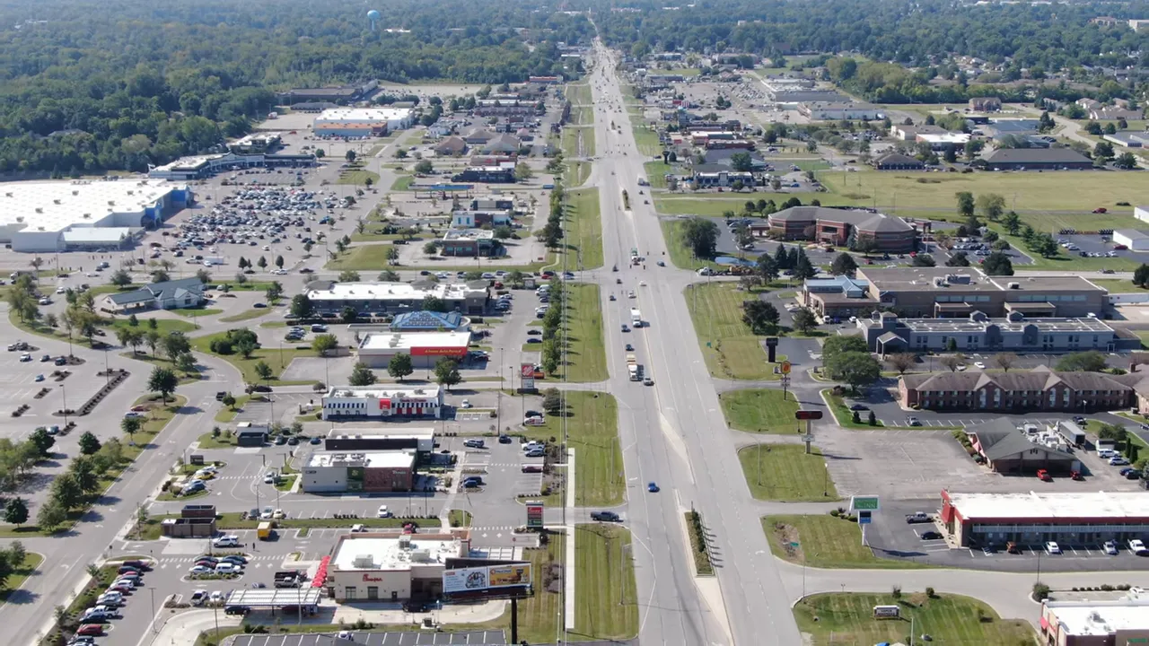Aerial view of Depot Street Park showing the pavilion stage, walkways, and nearby restaurant buildings in Greenfield