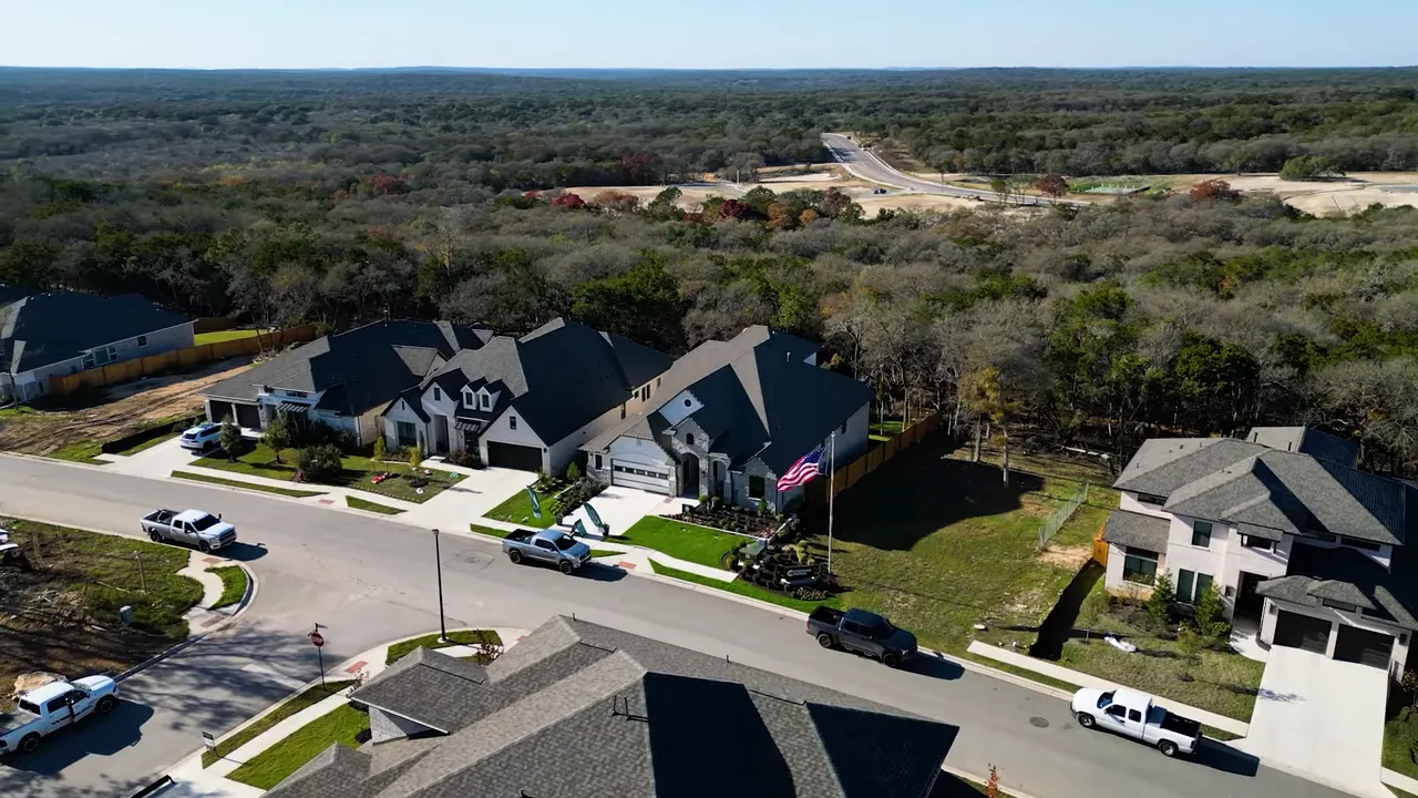 Aerial shot of Six Creeks neighborhood with overlay text '6 CREEKS', showing homes and surrounding trees