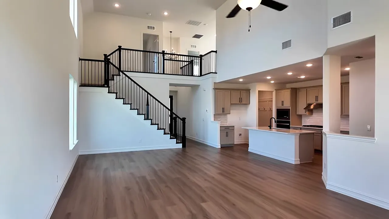 Two story open living area with staircase kitchen island and high ceilings