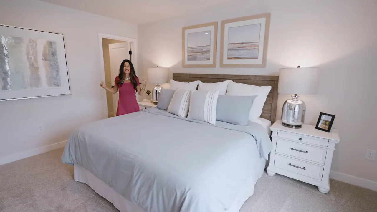 large upstairs bedroom with king bed nightstands and wall art