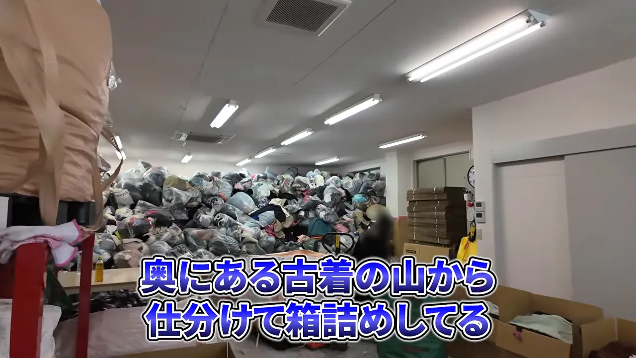 部屋の奥に大量の古着袋が山積みになっている様子