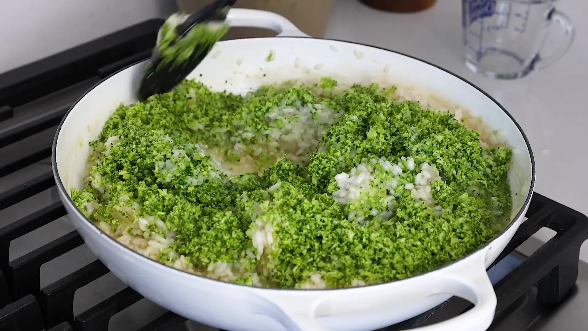 Stirring broccoli into risotto