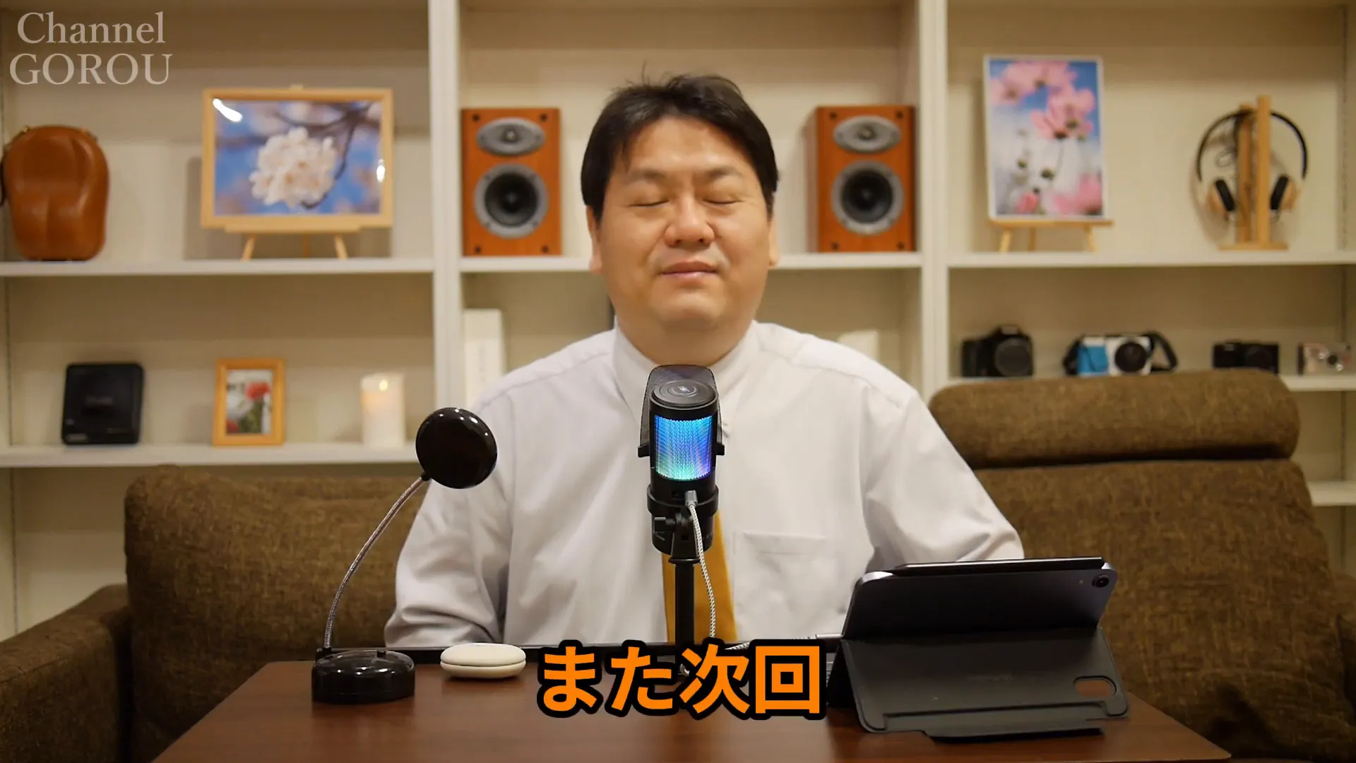 目を閉じて締めの挨拶をするレビュワー、中央にマイクと製品が見える終わりのカット